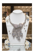 Collar de diamantes de imitación en colores de la aurora boreal que representa un pavo real montado sobre metal plateado.